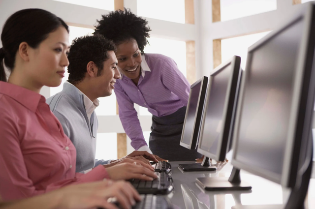 Smiling man and woman look at computer screen